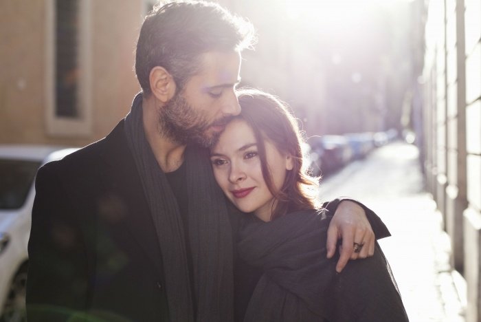 Парень обнимает девушку за плечи